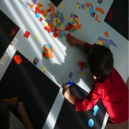 bambino crea collage con cartonini colorati